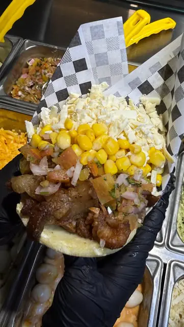 Canasta cargada de toppings, maíz y queso